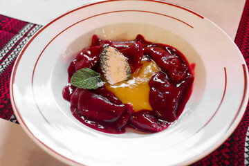 Cherry dumplings with spicy yellow sweet sauce. Traditional Ukrainian food.