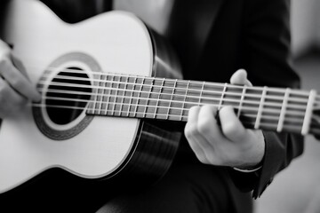 Obraz premium Close-up of a hand playing an acoustic guitar.