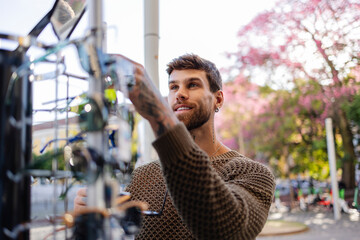 Handsome bearded man choosing sunglasses at outdoor display in lisbon, portugal
