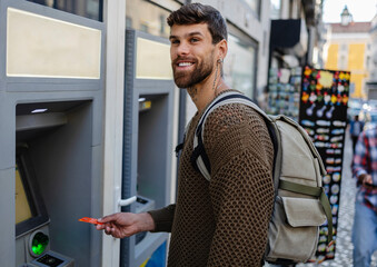 Tourist withdrawing cash at atm in portugal during vacation