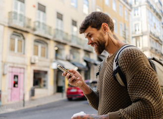 Smiling tourist using smartphone in lisbon, portugal
