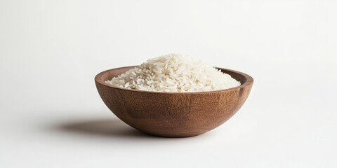 Rice in a wooden bowl is beautifully showcased against a clean white background, highlighting the textures and colors of rice in an elegant and simple presentation.