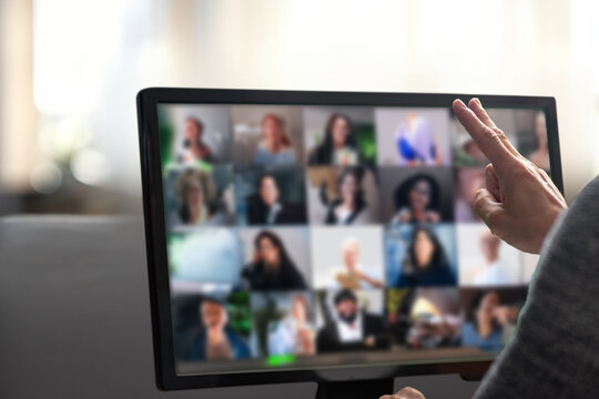 Man talking with diverse colleagues on virtual video conference using computer at home. Man working remotely in a home office, actively communicating during a virtual conference call