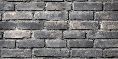 Fototapeta premium Textured old grey brick wall background showcasing the rustic charm and character of an aged grey brick wall, perfect for adding an authentic touch to various design projects.