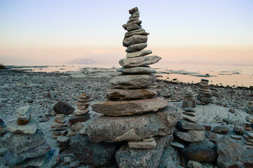 Balance pebble stone in the beach at sunset. Beautiful peaceful lake Garda, Italy. 