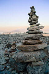 Fototapeta premium Balance pebble stone in the beach at sunset. Beautiful peaceful lake Garda, Italy. 