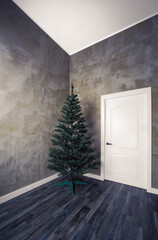 Christmas tree in an empty room with concrete walls