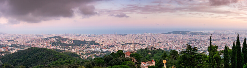 Panoramic view of Barcelona from a hilltop, capturing the sprawling cityscape against a dramatic...