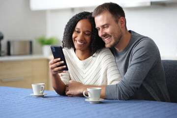 Happy interracial couple checking phone together