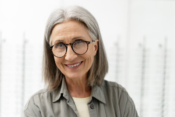 Senior woman smiling wearing stylish eyeglasses in optical store