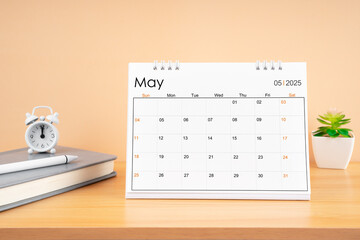 May 2025, Monthly desk calendar for 2025 year on wooden table.