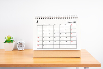 March 2025, Monthly desk calendar for 2025 year on wooden table.