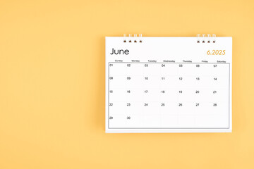 June 2025 desk calendar on yellow color background, position with copy space.