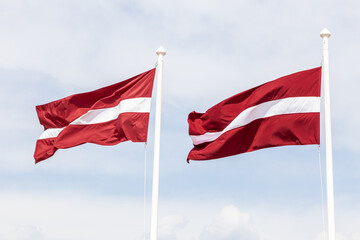 Two Latvian flags waving in the wind.