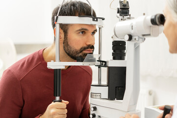 Optometrist examining patient's eyesight with slit lamp biomicroscope in ophthalmology clinic