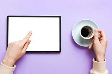 Close up image woman hands holding digital tablet with blank copy space screen for your text message or promotional content om table with cup of coffee. hands of a woman holding blank tablet device