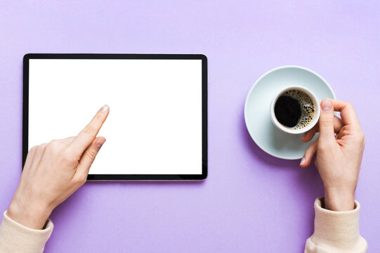 Close up image woman hands holding digital tablet with blank copy space screen for your text message or promotional content om table with cup of coffee. hands of a woman holding blank tablet device