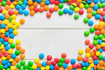 Mixed collection of colorful candy, on colored background. Flat lay, top view. frame of colorful chocolate coated candy