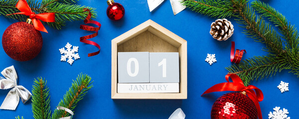 Christmas calendar 1 january. Christmas gift, fir branches, pine cones. Flat lay, top view. New Year decorations on a colored background