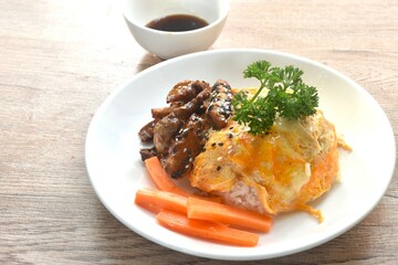 grilled slice pork with egg and sesame dressing teriyaki sauce topping on Japanese rice in plate