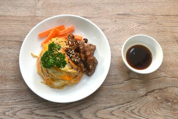 grilled slice pork with egg and sesame dressing teriyaki sauce topping on Japanese rice in plate