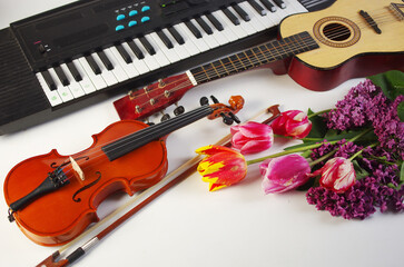 Naklejka premium Guitar, violin, synthesizer and a bouquet of tulips and lilacs.