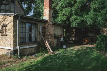 Rustic cottage with brick chimney and greenery.
