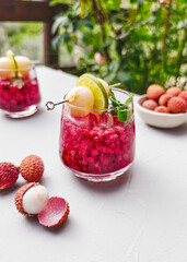 Refreshing lychee drink with raspberry, lime, mint leaves and ice. Non-alcoholic sparkling cocktail fizzy drink perfect for summer hydration.