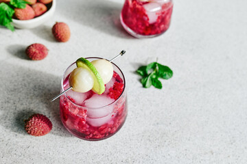 Refreshing lychee drink with raspberry, lime, mint leaves and ice. Non-alcoholic sparkling cocktail fizzy drink perfect for summer hydration.