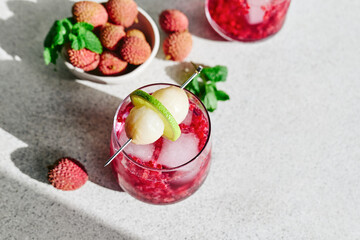 Refreshing lychee drink with raspberry, lime, mint leaves and ice. Non-alcoholic sparkling cocktail fizzy drink perfect for summer hydration.