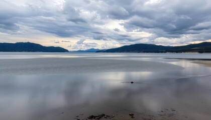 Obraz premium a view of a body of water with mountains in the background
