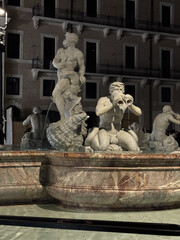 Naklejka premium In a historic city square, illuminated by soft lighting, majestic statues of mythological figures