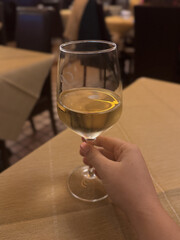 Enjoying a glass of white wine at a cozy restaurant table