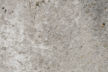 Cracked concrete wall covered with gray cement surface. Grey old wall with shabby damaged plaster or cement and brick background of an vintage dirty exfoliating plaster. Mock up.