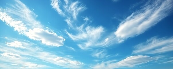 Clear blue sky with faint, fluffy white clouds scattered lightly.