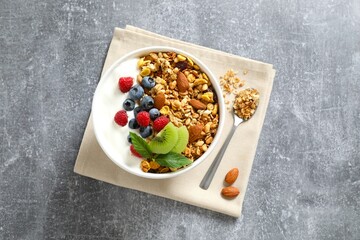 Delicious granola with berries and yogurt on a gray background