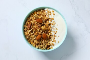 Delicious granola with yogurt on a light background