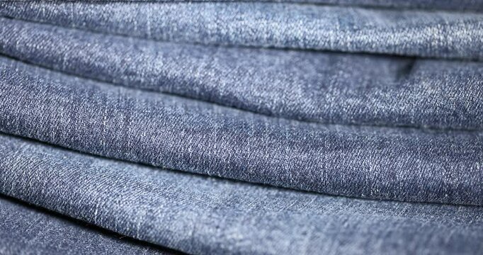new blue denim fabric for the production of clothing and other items, the details of a piece of sturdy denim fabric for the production of clothing, folded fabric group