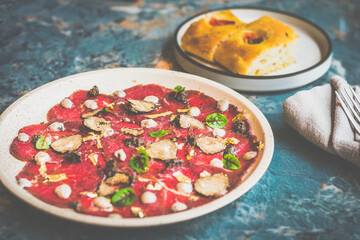 Angus Beef Carpaccio Thinly sliced raw Australian beef shaved fresh seasonal truffle, Italian truffle puree, sliced Grana Padano cheese, bread on the side