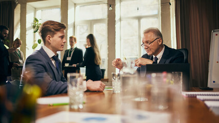 Senior businessman and young employee discuss career strategies and long-term goals, leader offering advice to young worker. Concept of business, professional development, support, mentorship