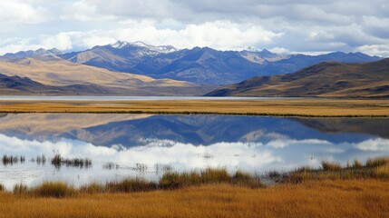 Obraz premium Mountain lake reflecting snowy peaks in autumnal landscape
