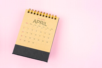 Brown calendar for April 2025 on pink background. Planning concept.