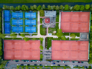 Aerial view of orange tennis courts and blue colored padel courts