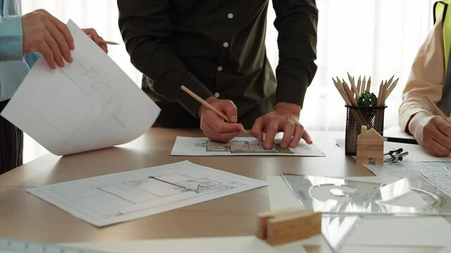 Professional engineer measuring the blueprint. Professional engineer working architectural project at studio on a table with yellow helmet and architectural equipment scatter around. Delineation.