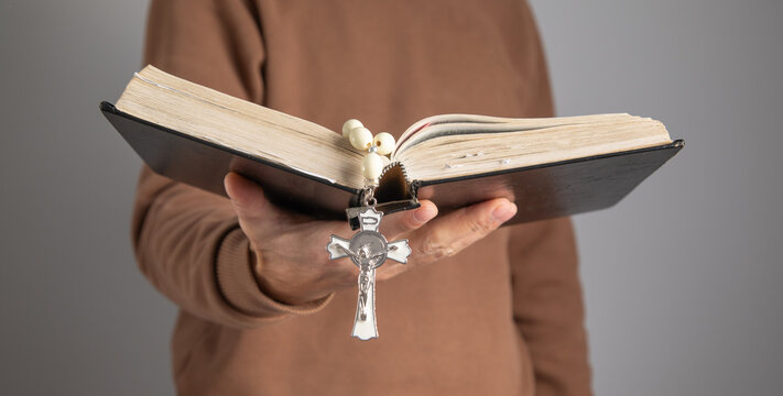 Man with a Holy Bible and rosary beads.