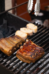 Marinated pork ribs are cooked on the coals of a barbecue