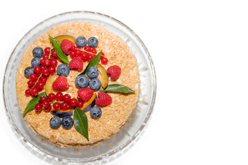 The homemade baked cake with berries and leaves for decoration.