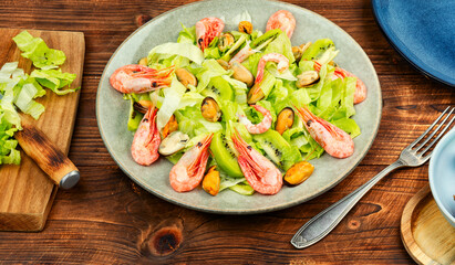 Seafood salad with shrimps and mussels on plate.