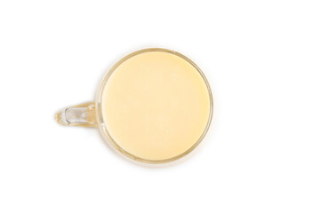 Organic non dairy banana and soy milk in glass isolated on white, top view, close up.