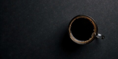 Aromatic Dark Roast Coffee in a Clear Glass Mug on a Dark Surface